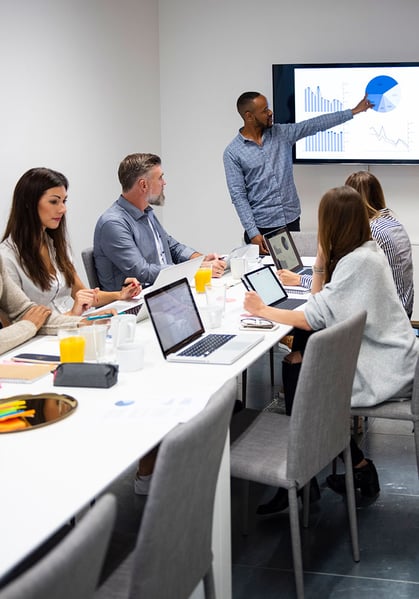 Young businessman giving presentation to his colleagues in modern office