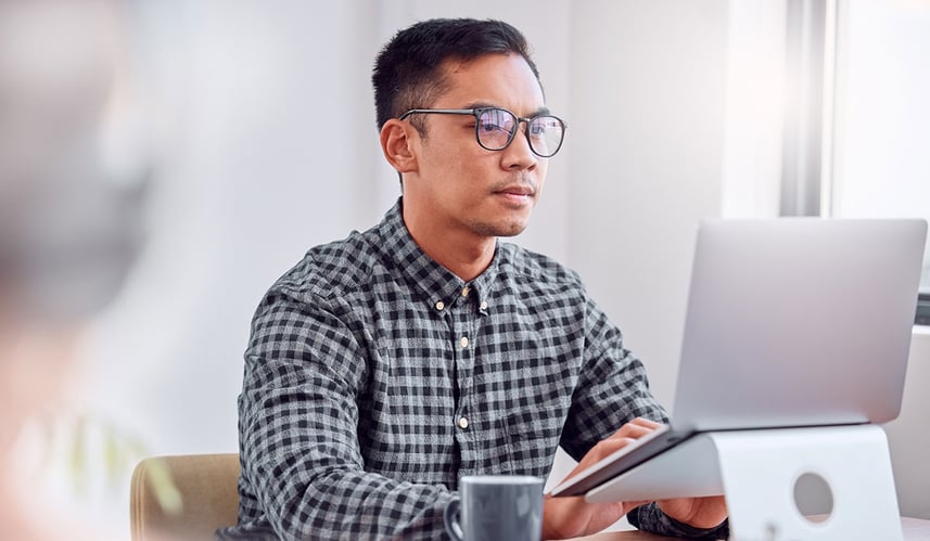 Person sat at desk looking at a computer