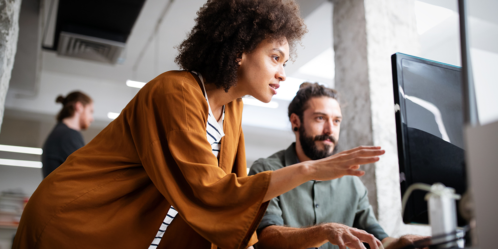 Two colleagues working together at a computer