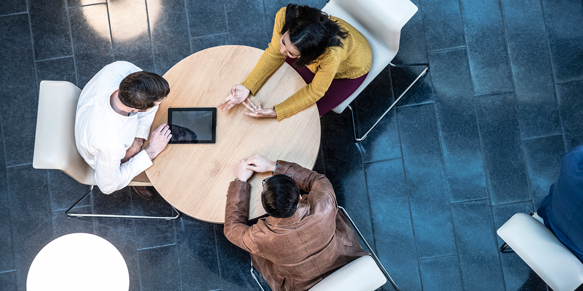 Birds-eye view of a group sat working remotely at a table.