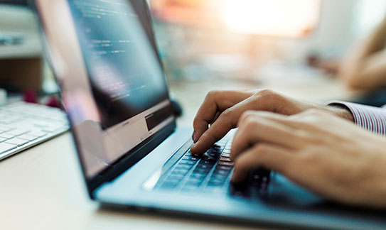 A person typing on a laptop