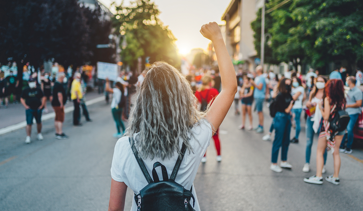 Young woman with a raised fist protesting in the street