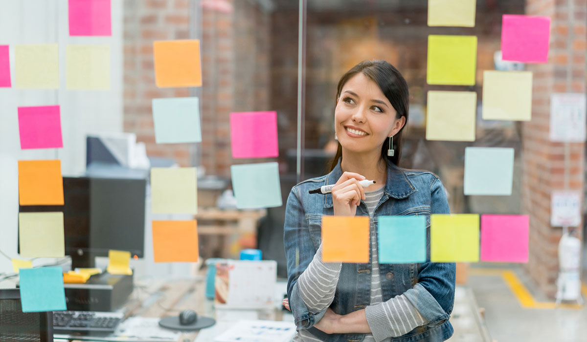 Person thinking of creative ideas at the office to put in a wall chart