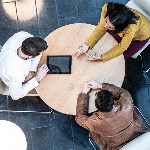 Three colleagues sat around a table