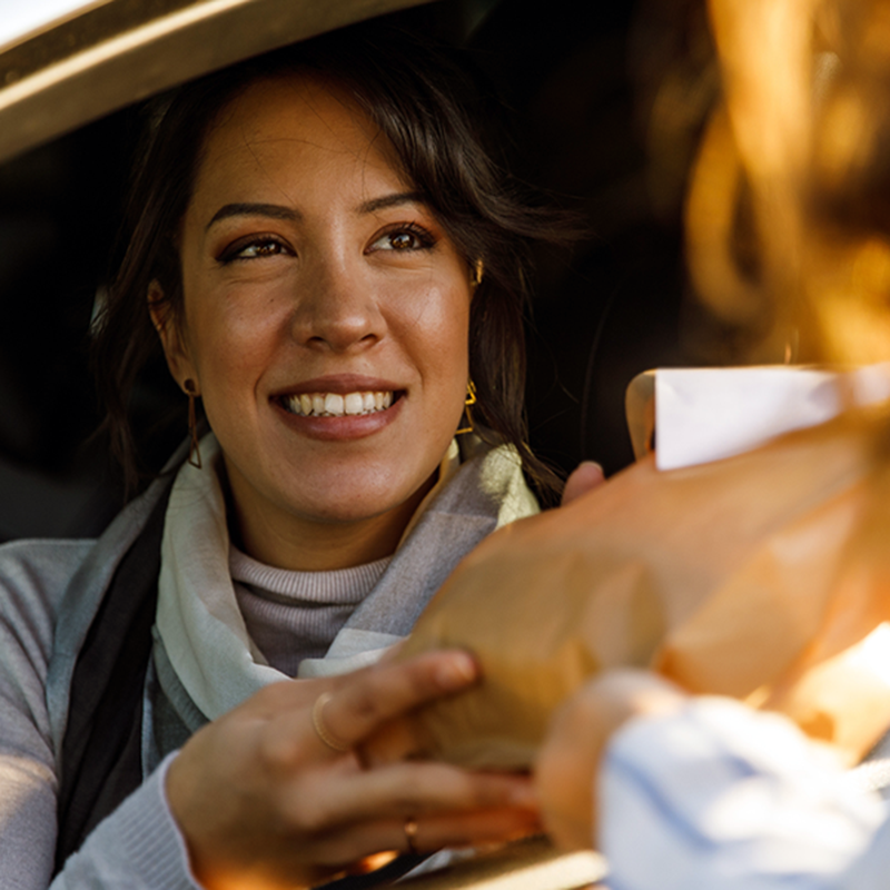Someone receiving an order at a drive-through
