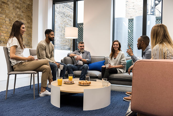 Group of people sat around a small table having a discussion